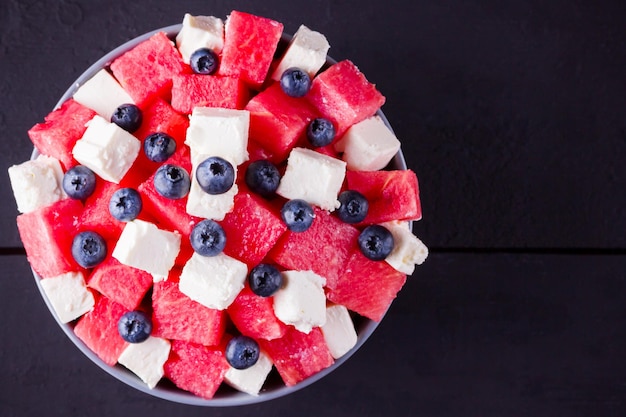 Salade de pastèque avec fromage feta dans un bol gris Salade saine avec des bleuets pastèque