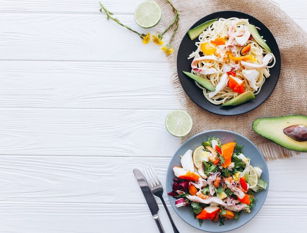 Salade et pâtes aux fruits de mer sur fond blanc