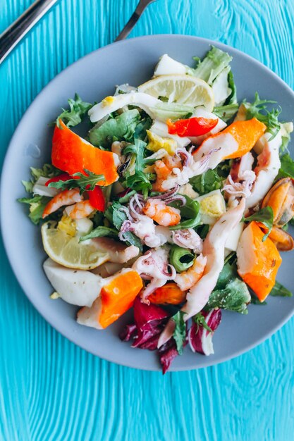 Salade et pâtes aux fruits de mer sur fond bleu