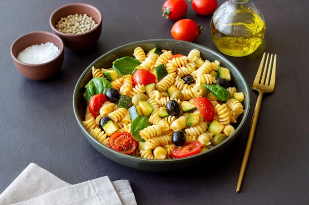 Salade de pâtes aux tomates, courgettes, olives et épinards. Alimentation saine. La nourriture végétarienne.