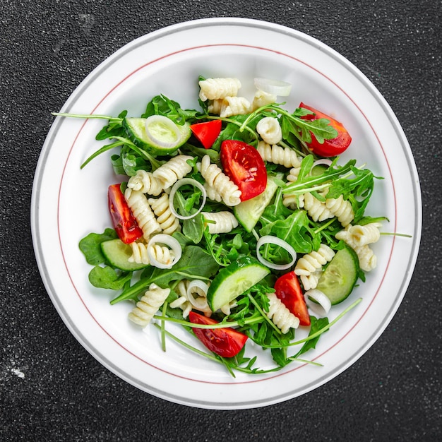 Photo salade de pâtes fusilli pâtes concombre tomate laitue verte oignon délicieux cuisine saine