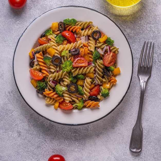 Salade de pâtes à la tomate, brocoli, olives noires. Vue de dessus