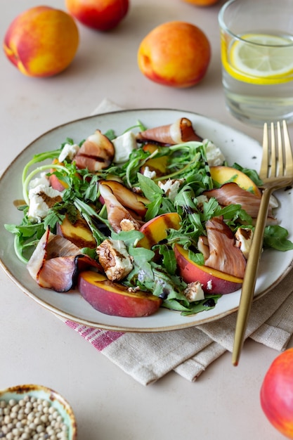 Salade de pêches, roquette, fromage et jambon. Alimentation équilibrée.