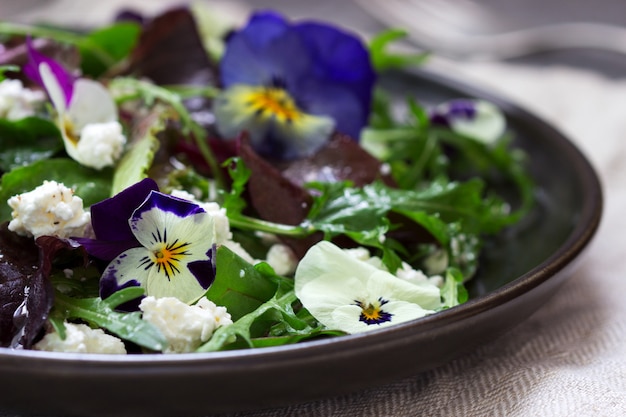 Salade de pensées et d'herbes assaisonnées d'huile végétale, de jus de citron et d'épices.