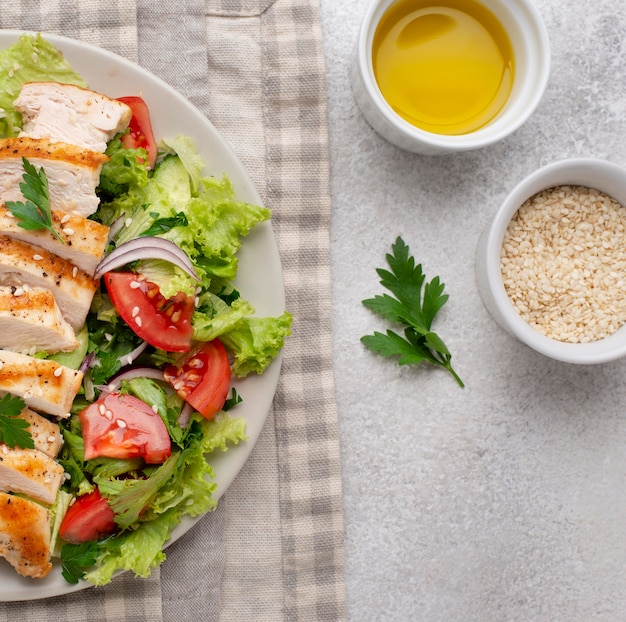 Photo salade plate au poulet, graines de sésame et huile