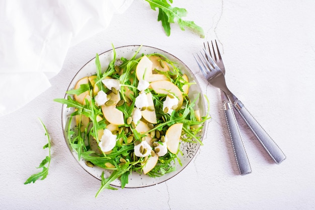 Salade de poires au fromage de roquette et graines de citrouille sur une assiette Déjeuner vitaminé fait maison Vue de dessus