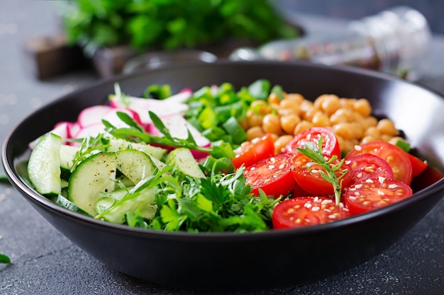 Salade de pois chiches, tomates, concombres, radis et légumes verts. Aliments diététiques. Bol de Bouddha. Salade végétalienne.