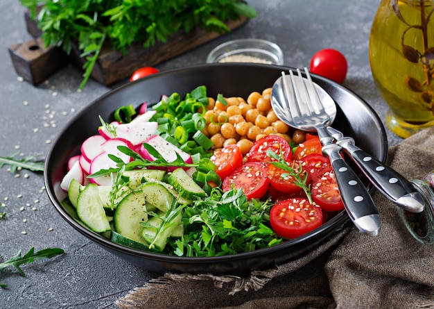 Salade de pois chiches, tomates, concombres, radis et légumes verts. Aliments diététiques. Salade végétalienne.