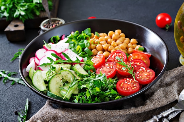 Salade de pois chiches, tomates, concombres, radis et légumes verts. Aliments diététiques. Salade végétalienne.