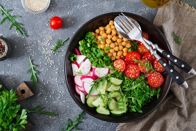 Salade de pois chiches, tomates, concombres, radis et verts. Aliments diététiques. Salade végétalienne. Haut