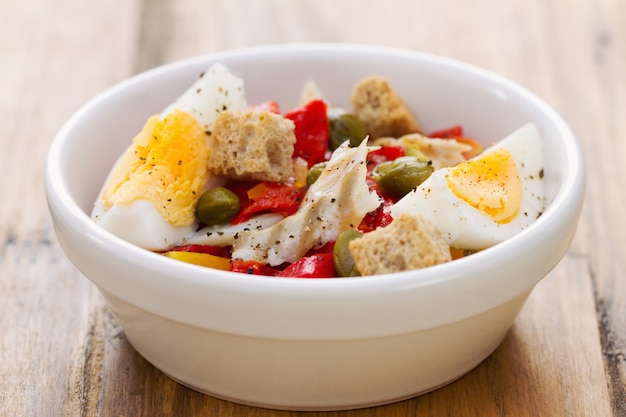 Salade de poisson et oeuf dans un bol blanc