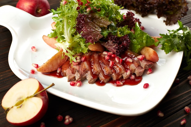 Salade de poitrine de canard suvide sur une table en bois