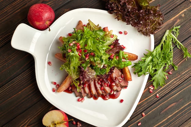 Salade de poitrine de canard suvide sur une table en bois