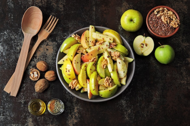 Salade de pommes végétalienne dans un bol. Salade saine aux pommes, noix, épices et graines de lin.