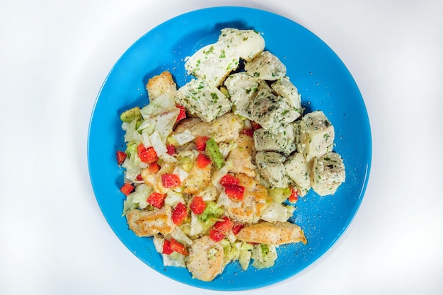 Salade de poulet aux épinards et pommes de terre croustillantes habillée d'huile d'olive ail citron oignon et thym