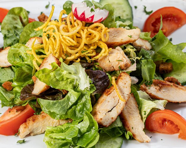 salade de poulet avec feuilles de laitue verte tomates rouges et vinaigrette au yogourt