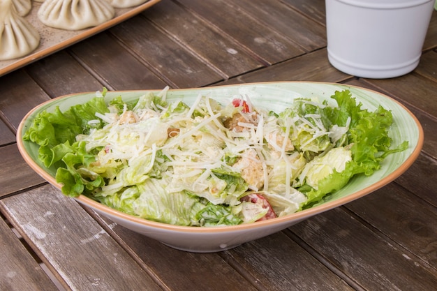 Salade de poulet avec laitue iceberg et croûtons sur la table en bois