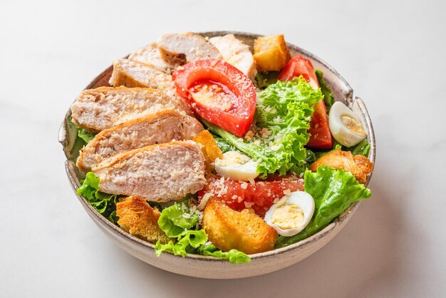 Salade de poulet Salade César avec filet de poitrine de poulet dans une assiette sur fond blanc Aliments diététiques sains