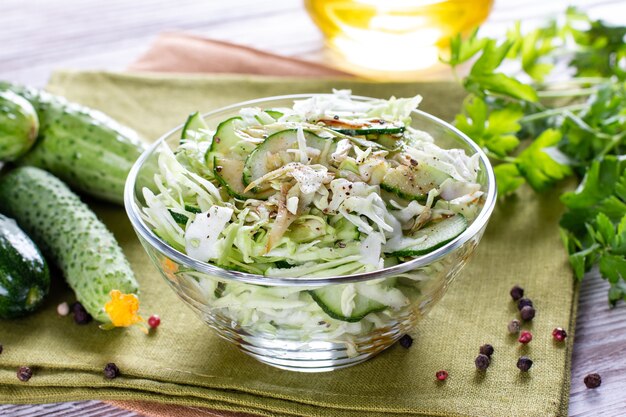 Salade printanière détox de légumes verts (chou, concombre, oignon vert et persil) sur une assiette.