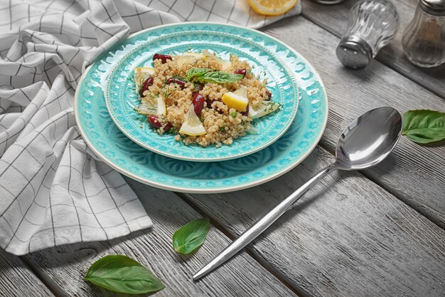 Salade de quinoa, basilic et haricots servis sur fond de bois gris