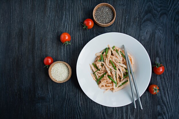 Salade de radis daikon, oignons verts, miel et poudre de chili rouge. Salade asiatique. Lay plat. . Sombre .