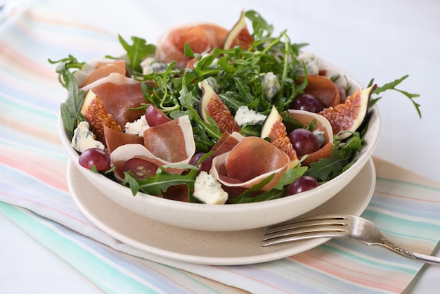 Salade de roquette au jambon de Parme, fromage bleu, figues, raisins