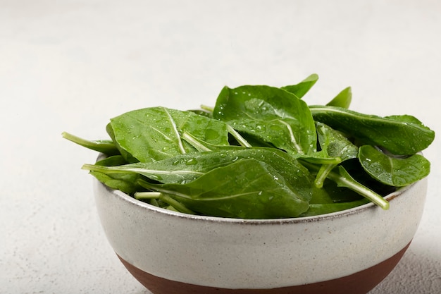 Salade de roquette dans un bol sur fond blanc