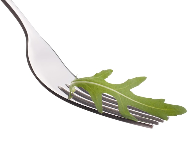 Salade de roquette fraîche sur fourche isolé sur fond blanc dentelle concept de saine alimentation