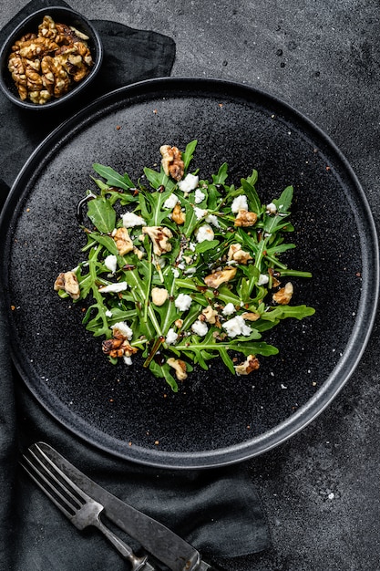 Salade de roquette, noix, fromage feta, huile d'olive, herbes. Vue de dessus