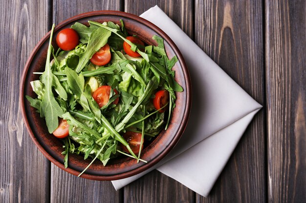 Salade de roquette et tomates cerises sur table en bois