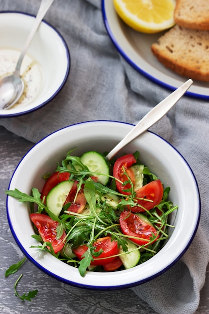 Salade de roquette, tomates, concombres et sauce au citron.