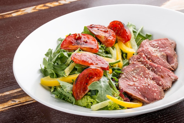 Salade de rôti de boeuf et tomates séchées sur fond sombre