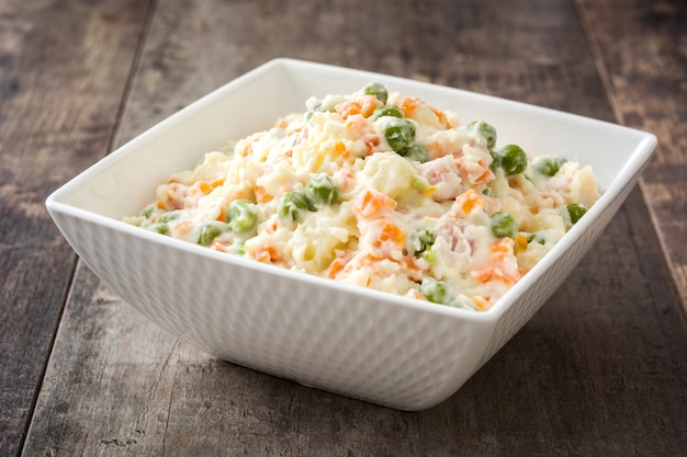 Salade russe dans un bol sur une table en bois rustique