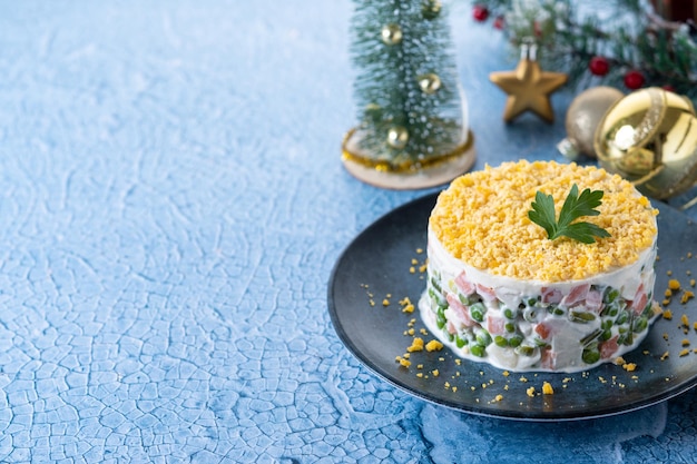 Salade russe ou salade Olivier pour le dîner de Noël sur une surface bleue