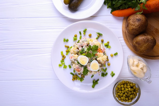 Salade russe traditionnelle Olivier pour Noël et nouvel an sur fond blanc avec place pour le texte.