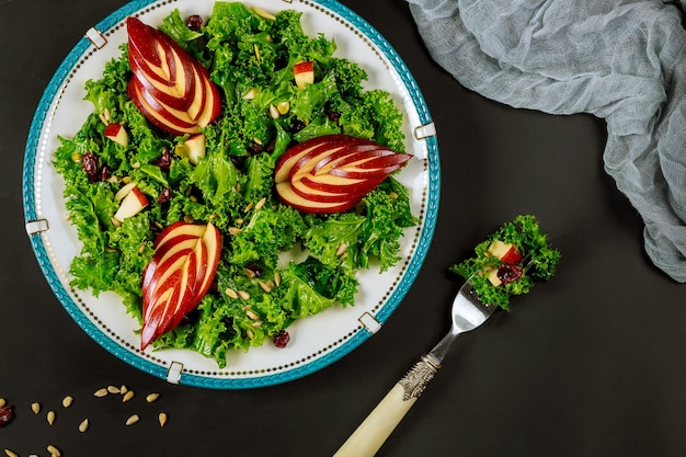 Salade saine avec chou frisé, pomme rouge, canneberge et graines de tournesol.