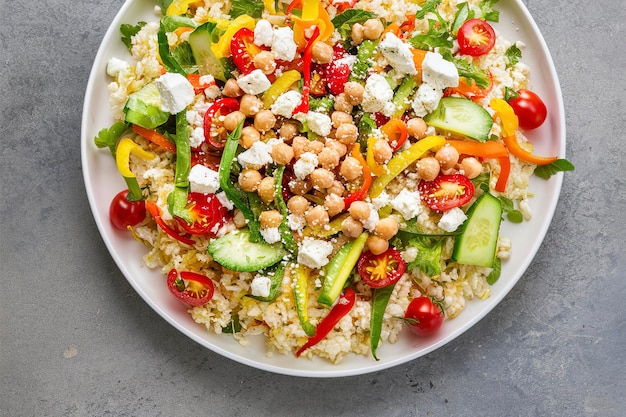 Salade saine à faible teneur en glucides avec du riz au chou-fleur, des légumes frais, du fromage feta et des pois chiches