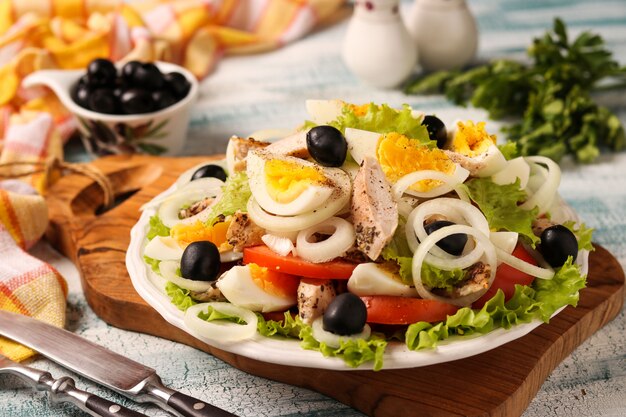 Salade saine de laitue biologique avec poulet, tomates, œufs, olives noires et oignons blancs