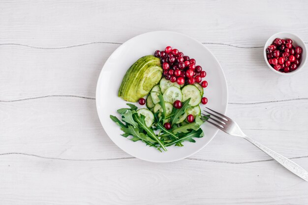 Salade saine avec roquette, avocat et baies et oeuf