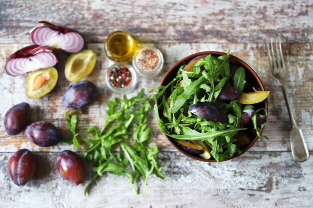 Salade saine avec roquette et prune dans un bol.