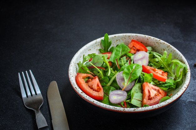 salade saine de tomates, mélange de feuilles, oignons et autres ingrédients