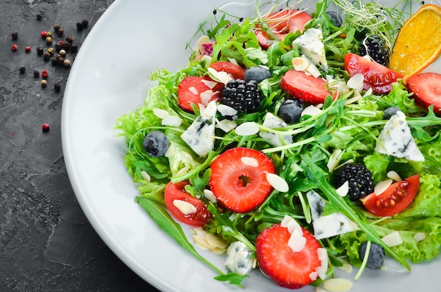 Salade. Salade de roquette, fromage bleu, fraises et myrtilles. Vue de dessus.