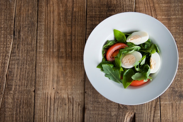 Salade santé avec œufs à la coque, tomates, laitue, roquette et épinards.