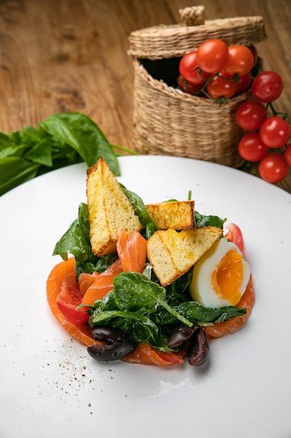 Salade de saumon sur une assiette avec oeuf et herbes