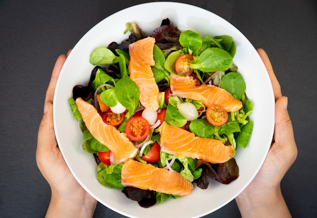 Salade de saumon frais aux tomates douces, ail mariné, oignons et épinards sont une alimentation saine