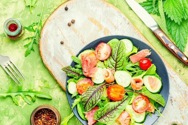 Salade savoureuse à la truite, tomate cerise, concombre et herbes