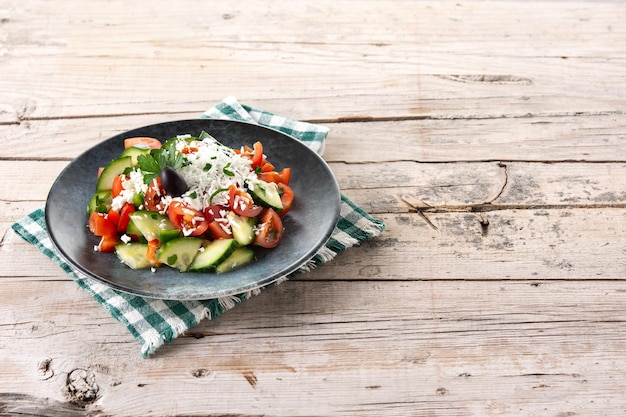 Salade de shopska bulgare traditionnelle avec concombre tomate et fromage sirene bulgare sur table en bois