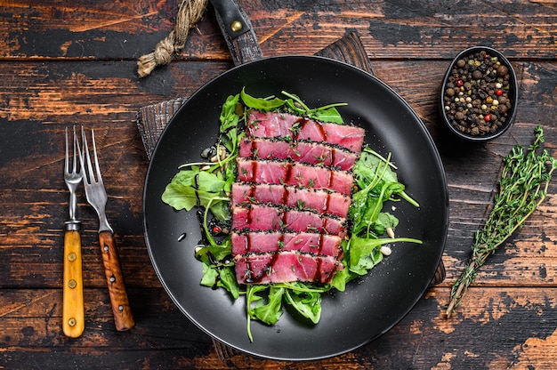 Salade de steak de thon teriyaki grillé avec roquette et épinards.