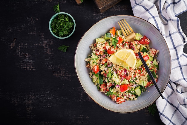 Salade de taboulé. Plat traditionnel du Moyen-Orient ou arabe. Salade végétarienne levantine avec persil, menthe, boulgour, tomate. Vue de dessus