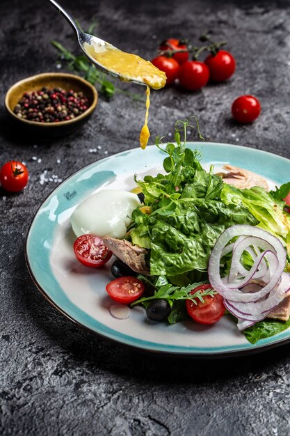 Salade de thon en conserve, avocat, poché, oeuf, laitue, cerise, tomates olives et maïs